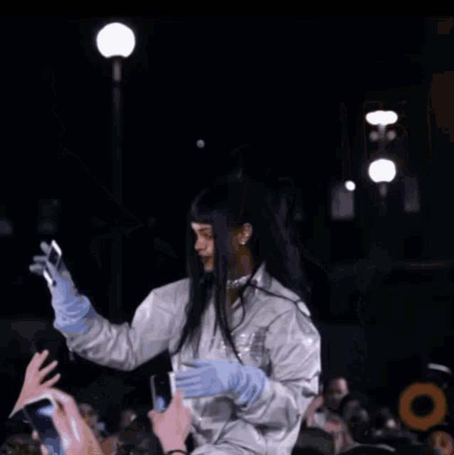 a woman in a white jacket is taking a picture with her phone