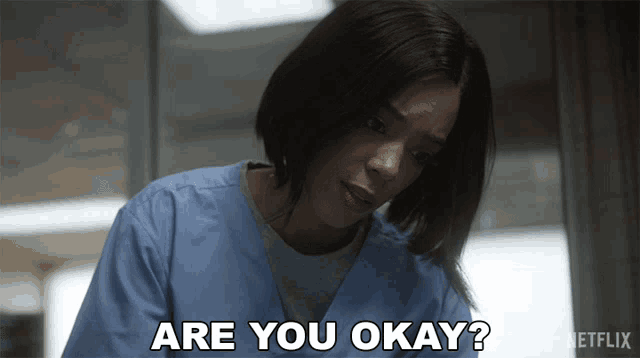 a woman in scrubs is asking if she is okay