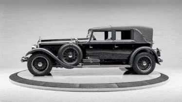a black car is sitting on a white circular display
