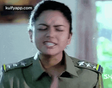 a woman in a military uniform is crying with her eyes closed and her mouth open .