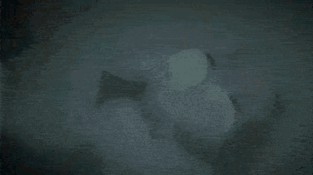 a man with a beard is holding a shield in a dark room