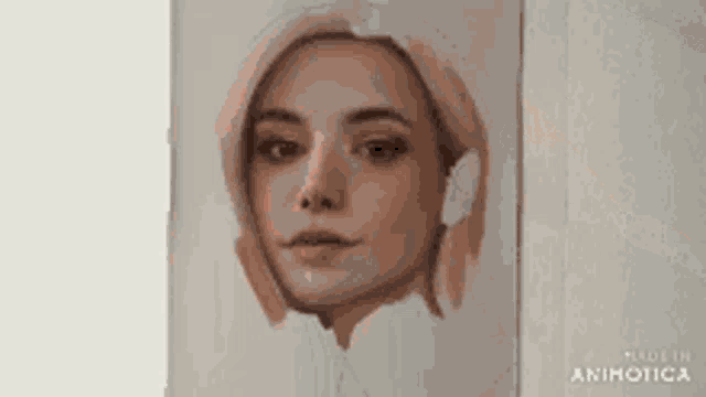 a close up of a painting of a woman 's face on a white wall .