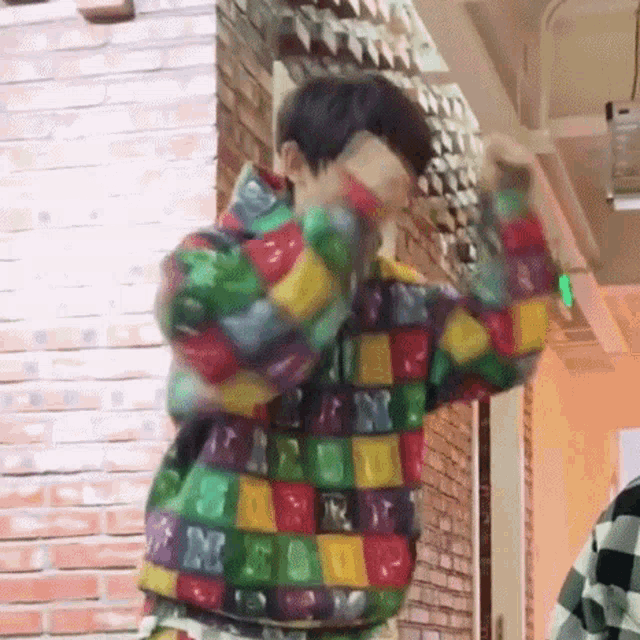 a man is wearing a colorful sweater with gummy bears on it .