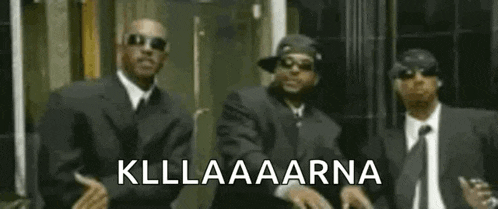 three men in suits and ties are standing next to each other with the words kllaaarna on the bottom .