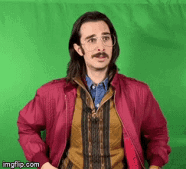 a man with glasses and a mustache wearing a pink jacket