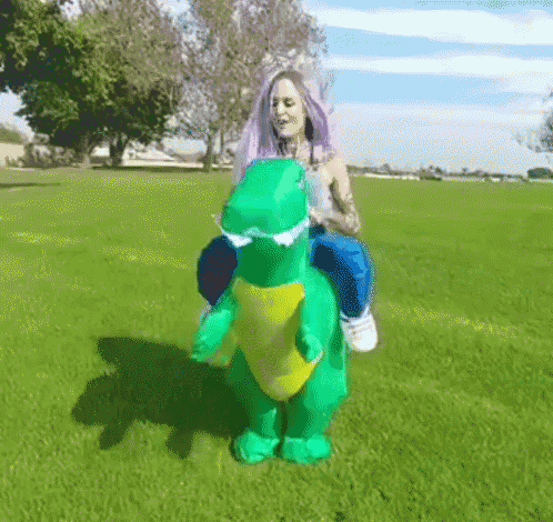 a woman is riding on the back of an inflatable dinosaur costume .