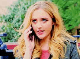 a woman is talking on a cell phone while wearing a jacket