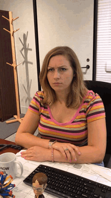 a woman sits at a desk with a mug that says tomorrow is a good day