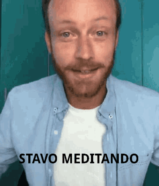 a man with a beard is wearing a blue shirt and a white t-shirt and says stavo meditando