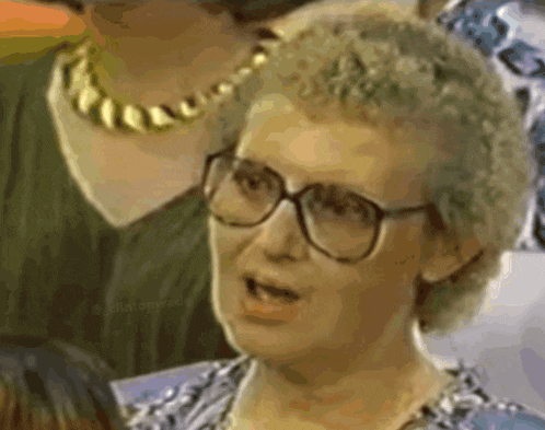 a close up of a woman wearing glasses and a necklace