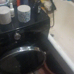 a bathroom with a toilet and a bathtub with bottles on top of it