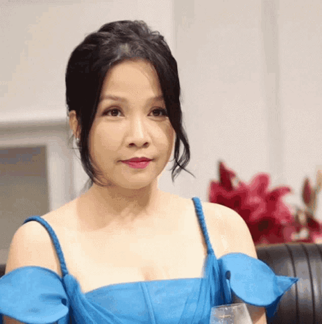 a woman in a blue dress is sitting in a chair