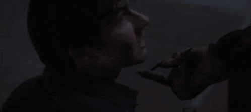 a close up of a man 's face in a dark room .