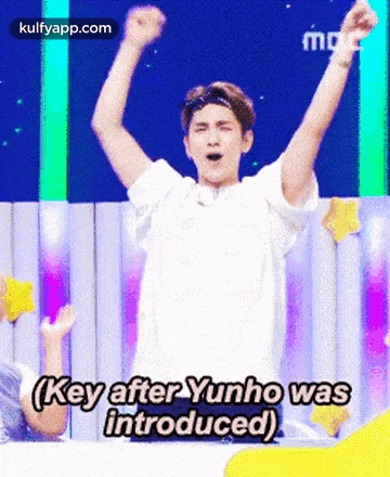 a man with his arms in the air says key after yunho was introduced .