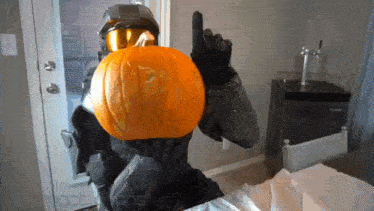 a man in a halo costume is holding a pumpkin on his head