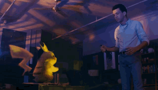 a man stands in a dark room holding a flashlight and looking at a cartoon character