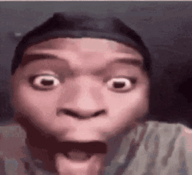 a man is making a funny face with his mouth open and his eyes wide open .