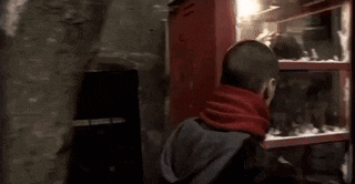a man in a red scarf is touching a glass door with his hand ..