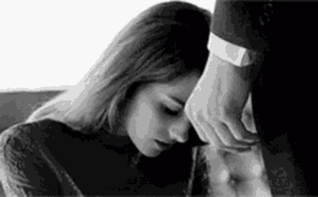 a man is touching a woman 's neck in a black and white photo .