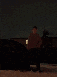 a man in a dark room with a light on the right