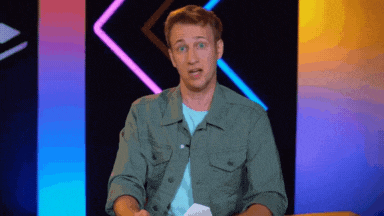 a man in a green jacket is talking on a stage