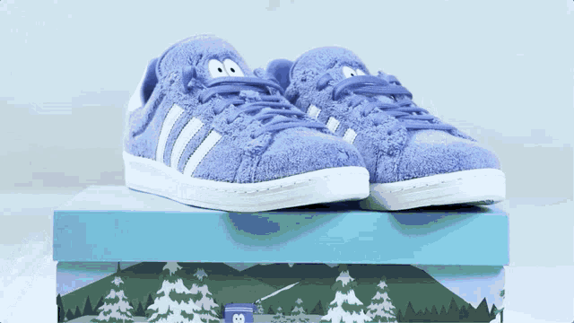 a pair of purple adidas shoes sitting on top of a box
