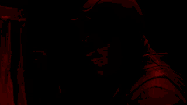 a man in a dark room with a red light on his head