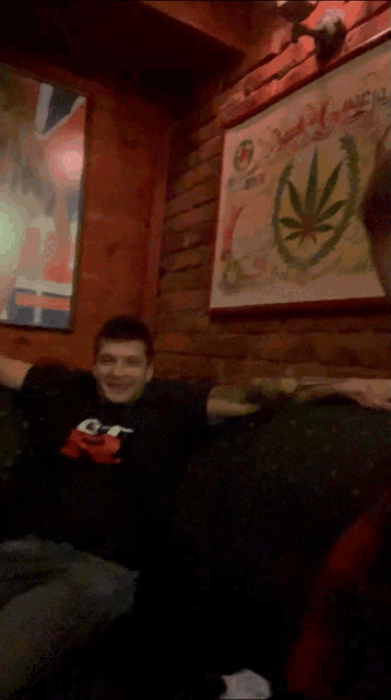 a man sitting on a couch wearing a shirt that says gt on it