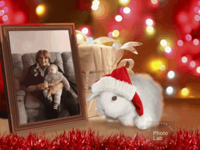 a picture of a woman holding a baby and a stuffed rabbit wearing a santa hat