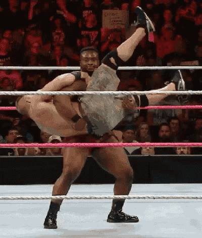 two wrestlers are wrestling in a ring with a sign that says ' a ' on it