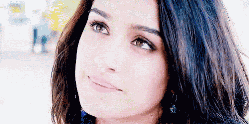 a close up of a woman 's face with a smile on her face and her eyes looking up .