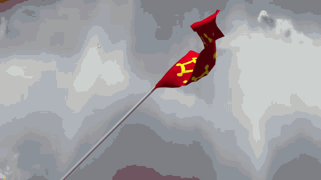 a red flag with a yellow x on it is flying in a cloudy sky