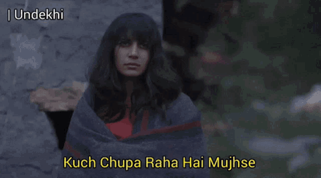 a woman wrapped in a blanket with a caption that says kuch chupa raha hai mujhse
