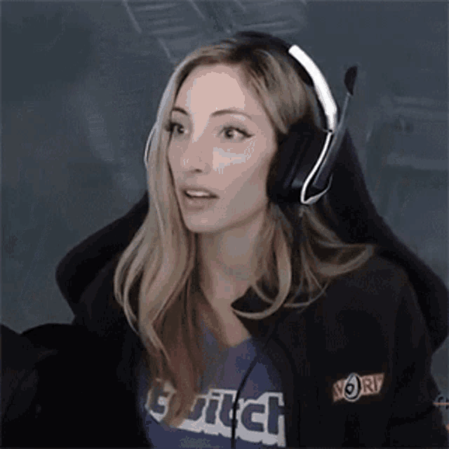 a woman wearing headphones and a purple shirt with the word twitch on it