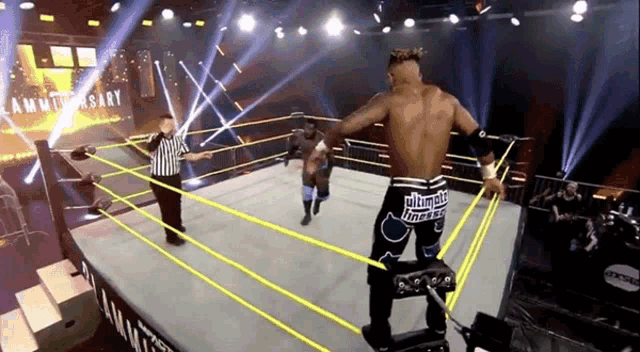 a wrestler in a wrestling ring with the word ultimate on his pants