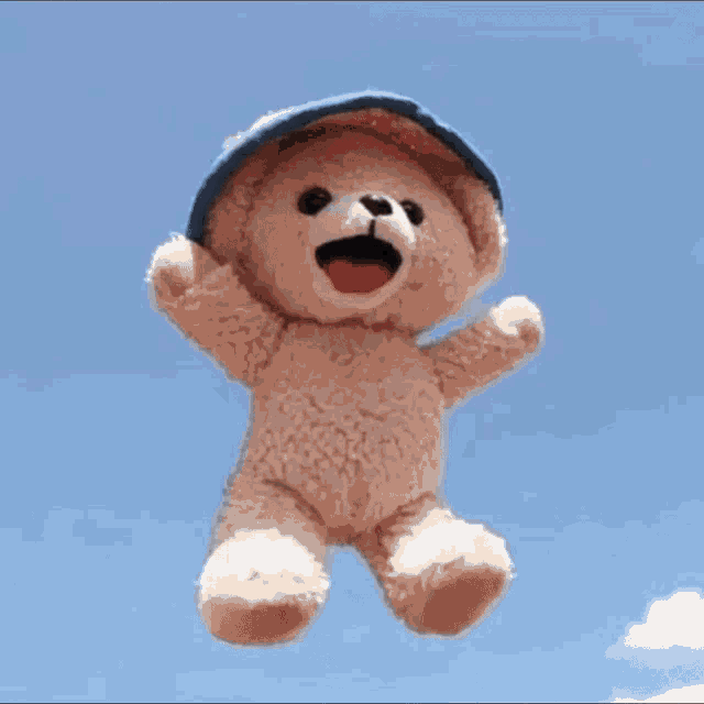 a man wearing a bucket hat and a black shirt is laughing with his mouth open .