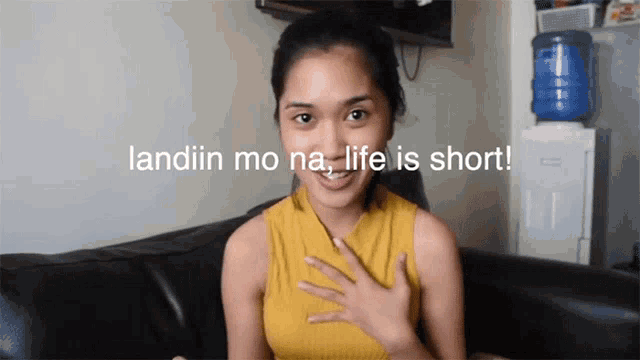 a woman sitting on a couch with the words " landin mo na life is short " behind her