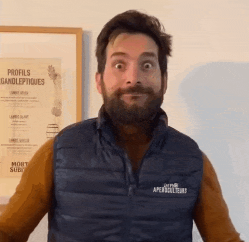 a man with a beard is wearing a vest that says aperolculteurs