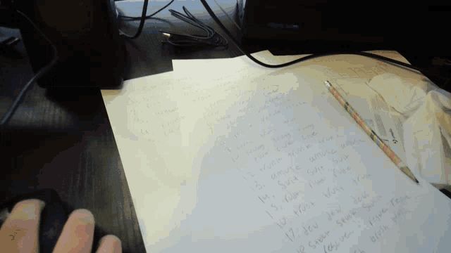 a person 's hand rests on a piece of paper with a list of numbers