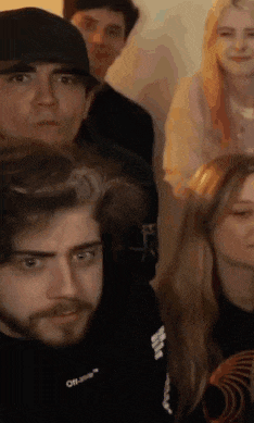a group of people are sitting in a room looking at the camera .