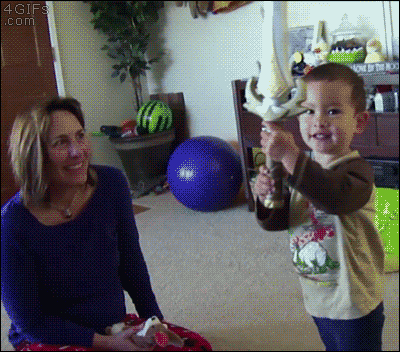 a little boy is holding a sword in front of a woman who is smiling at him ..