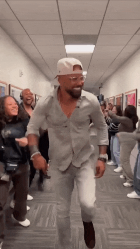 a group of people are dancing in a hallway .