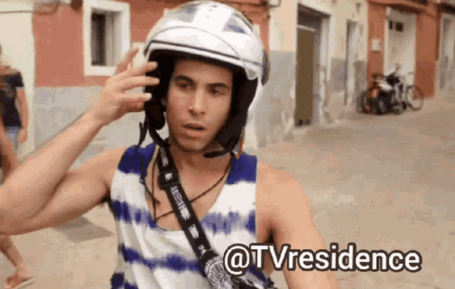 a man wearing a helmet is being helped by a woman with the caption @tvresidence