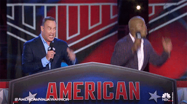 two men are standing behind a sign that says american