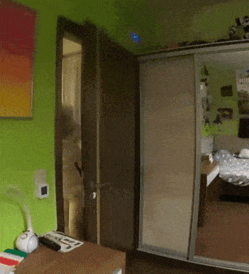 a bedroom with green walls and a large mirror