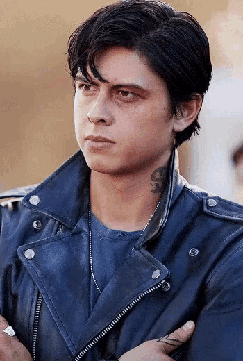 a young man with a tattoo on his neck is wearing a blue leather jacket