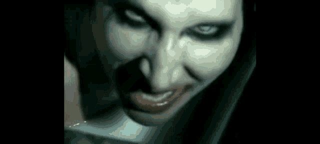 a close up of a woman 's face with blood coming out of her mouth and eyes .