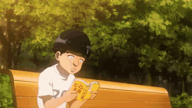 a young boy sits on a bench reading a book with chinese characters on the cover