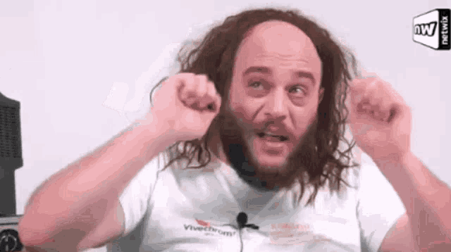 a man with long hair and a beard is wearing a vivechrom t-shirt