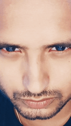 a close up of a man 's face with blue eyes